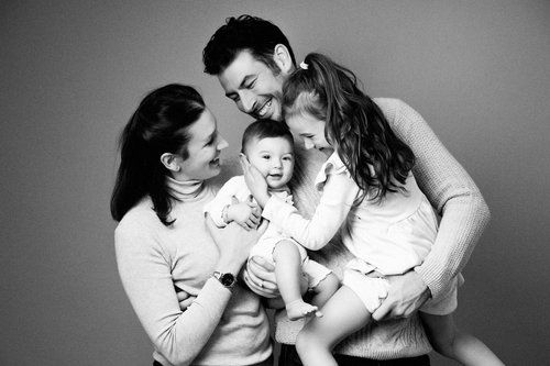 A joyful black and white family portrait showing tender moments of laughter.