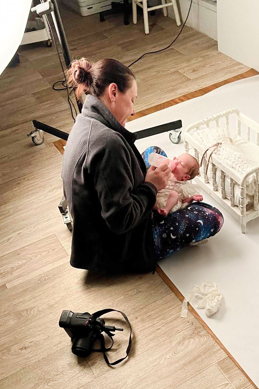 Fort Wayne IN area photographer feeding newborn in photography studio