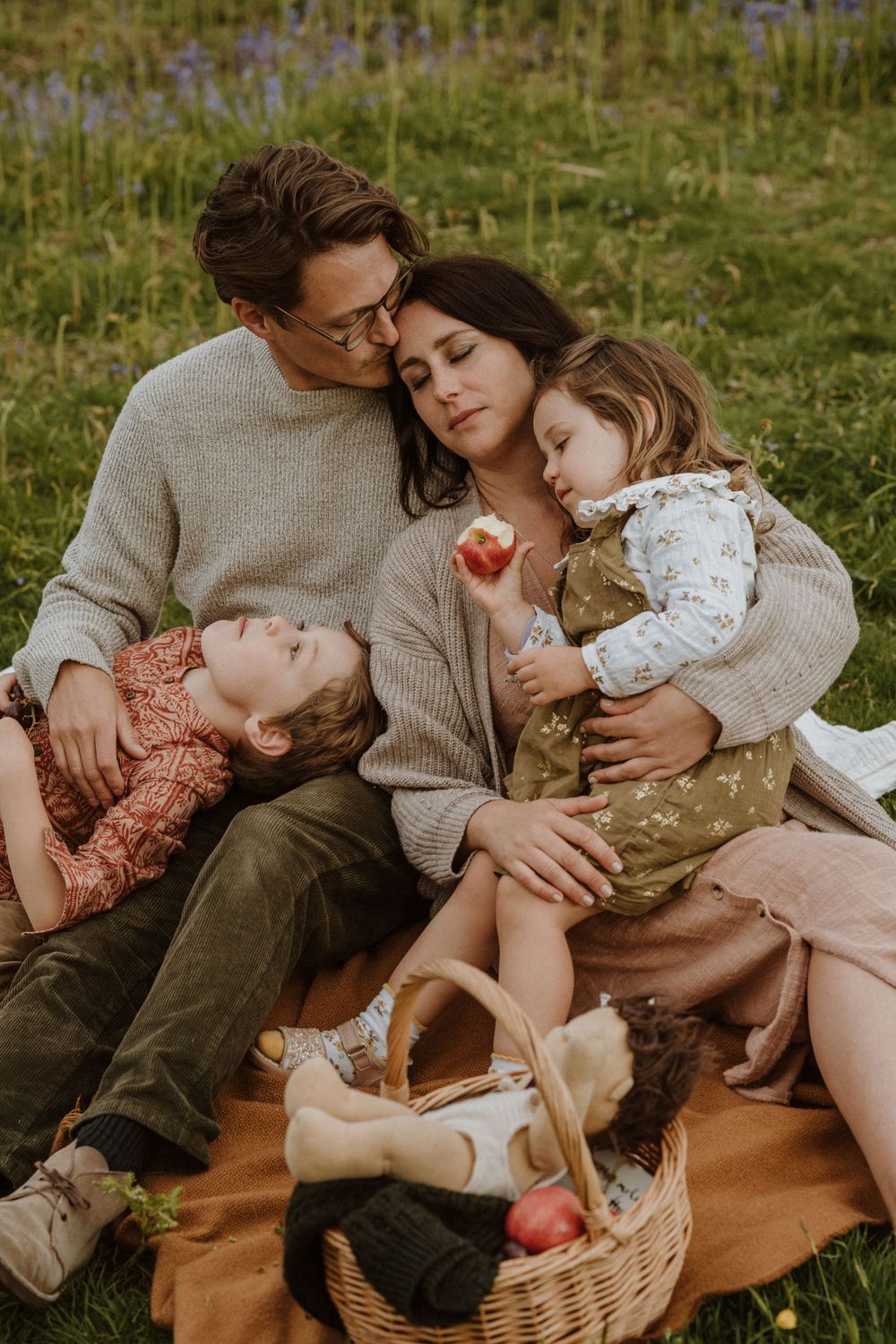 family of four cuddle up during photoshoot on a bluebell field in Dursley, UK