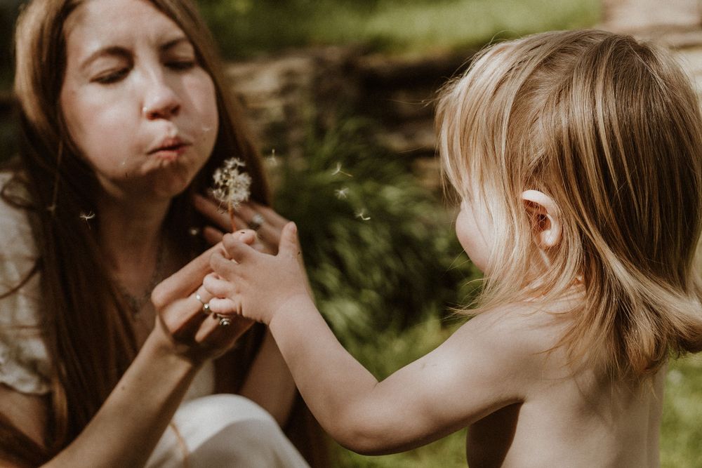 mum blows dandelion towards her son