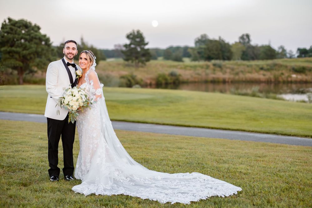 Wedding couple walking hand in hand across a scenic outdoor venue.