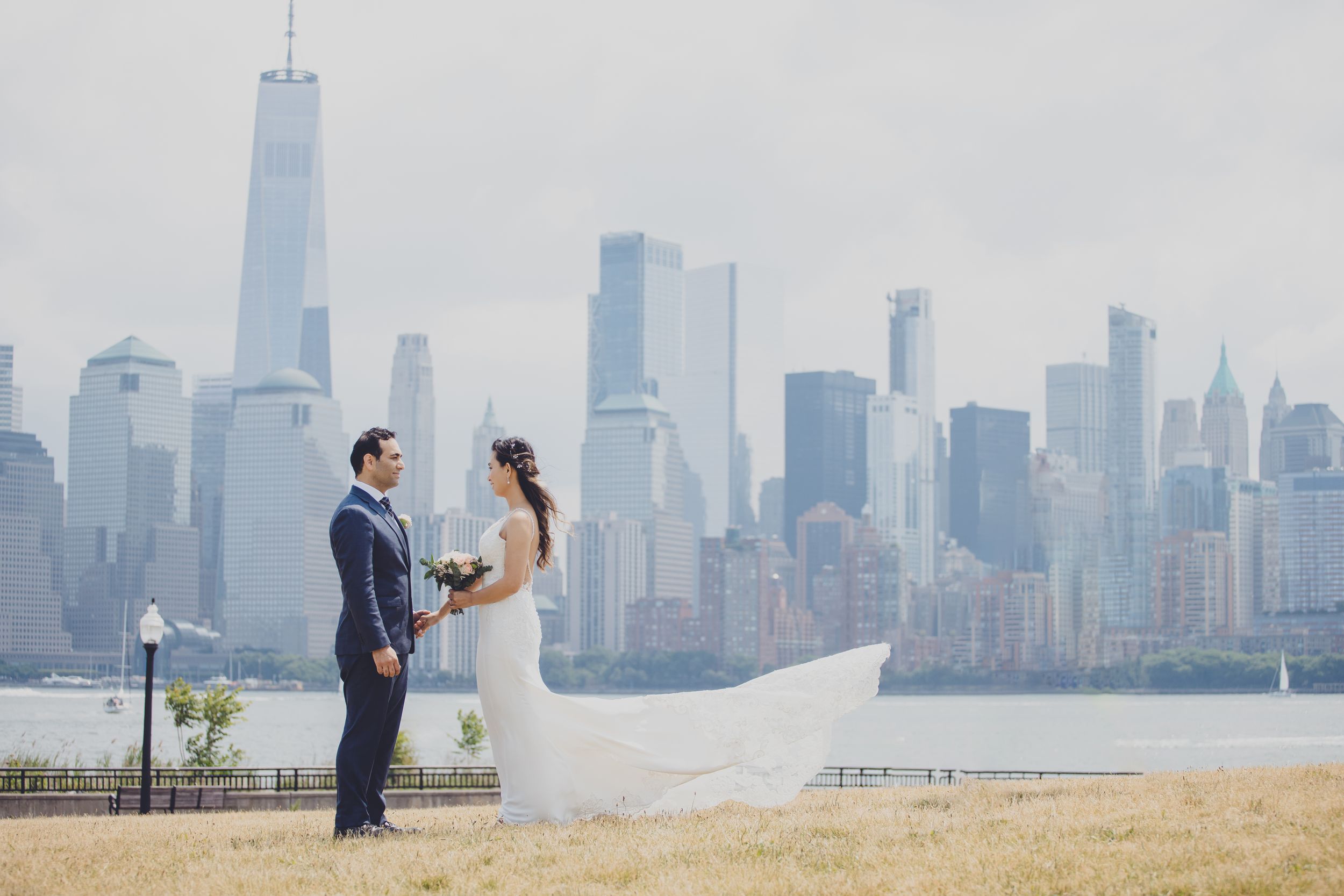 A couple shares an intimate moment with the New York City skyline as their backdrop.