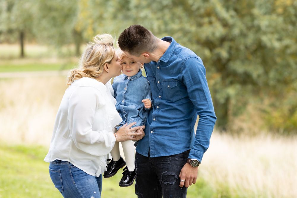 Family shares intimate moment together during outdoor autumn photoshoot.