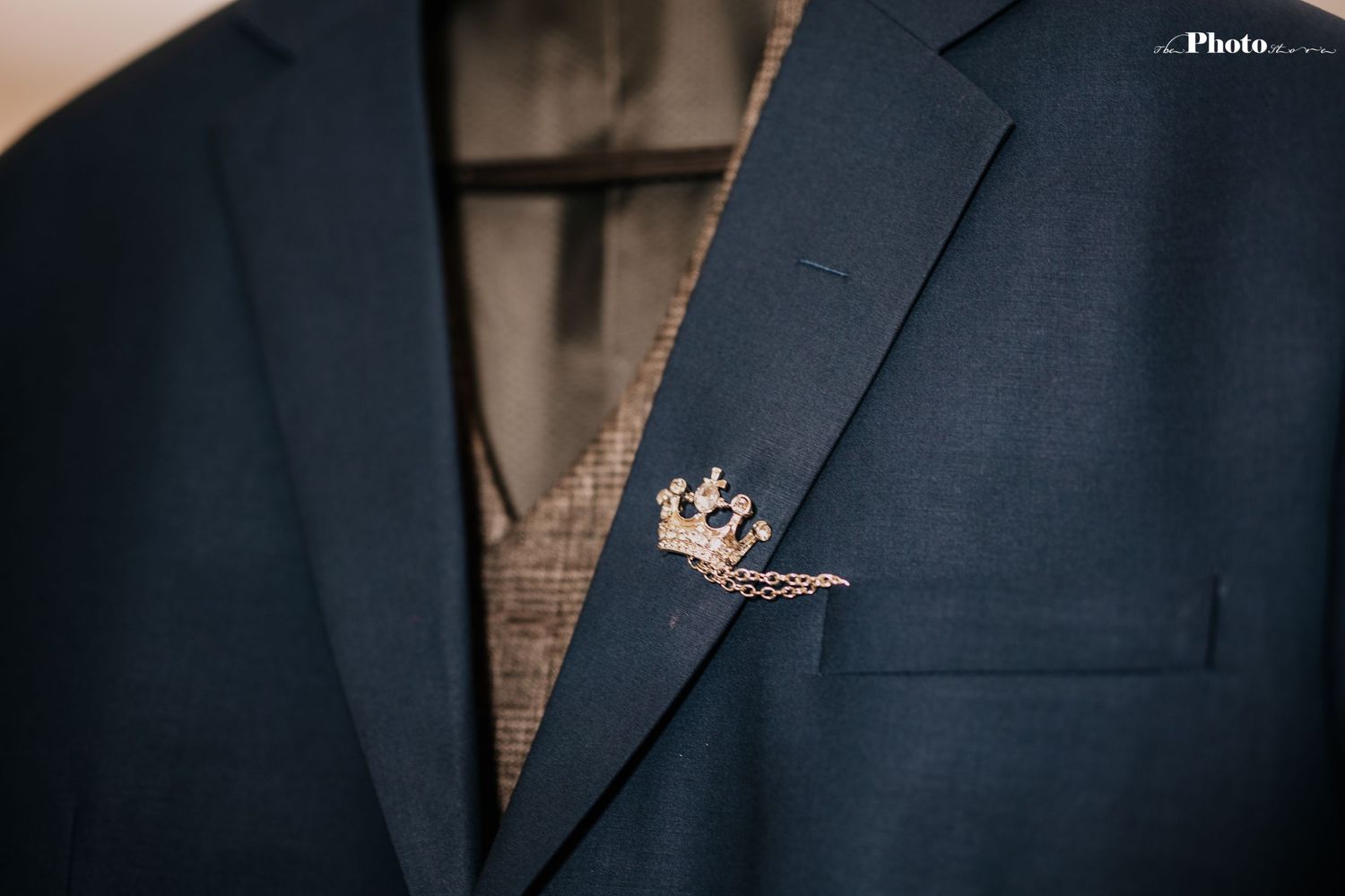 Close-up detail of dark blue textured suit jacket fabric.