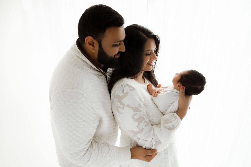 Newborn family session, by the window with a wrapped baby. Algonquin IL Newborn Photographer