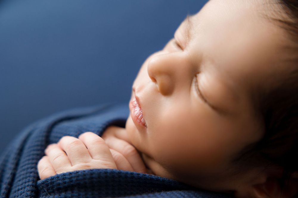 Newborn baby detail image, close up. Navy blue set up.
