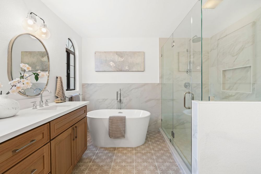 Luxurious bathroom with freestanding tub, wooden vanity, and marble tile accents.