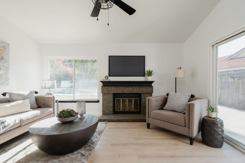 Minimalist living room with fireplace, large TV, and comfortable seating arrangement.