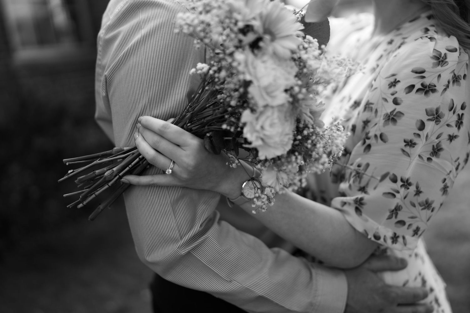 Black and white photo of someone holding a romantic bouquet of fresh flowers.