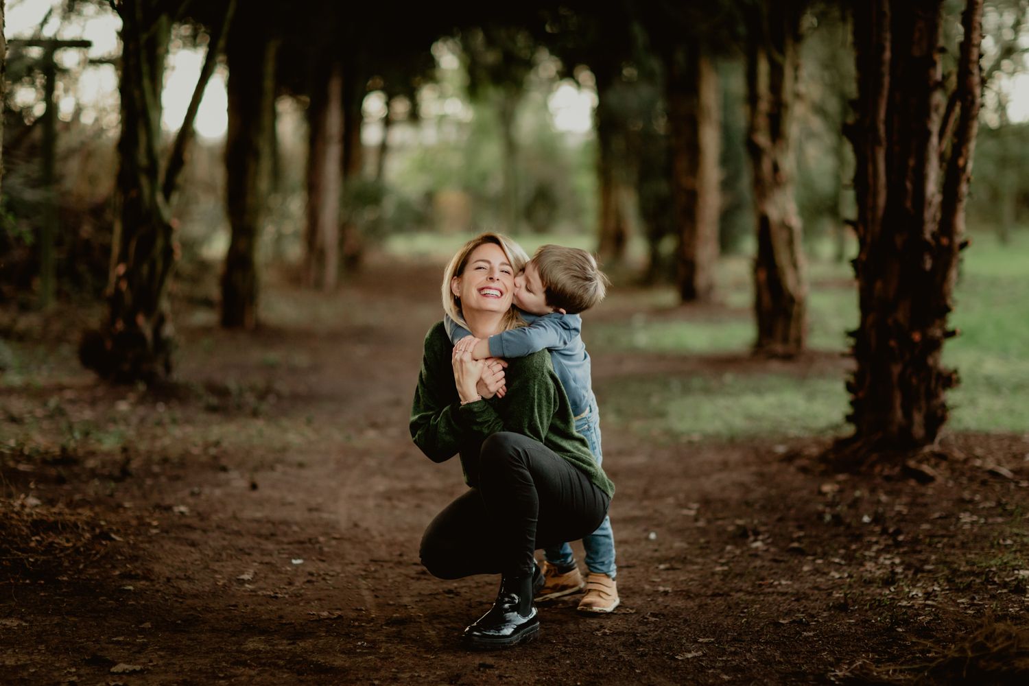 A playful moment captured in a wooded forest path with natural lighting.