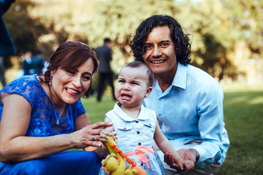 Family gathering on a grassy lawn during a sunny afternoon celebration.