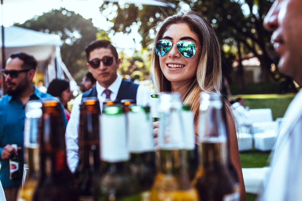 Wedding guests socializing and enjoying drinks at an outdoor reception.