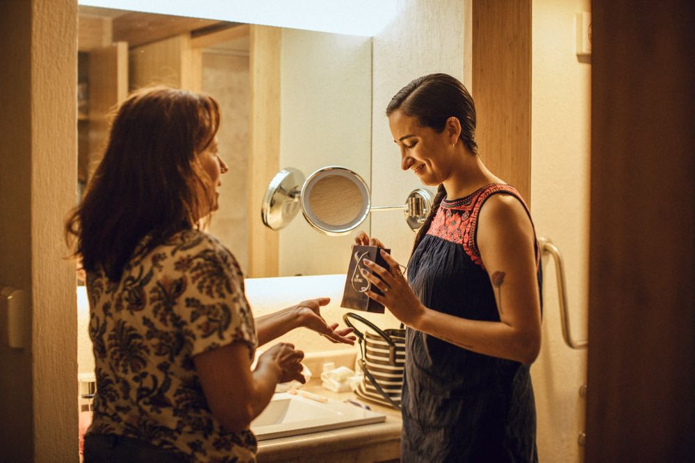Two people examining items in bathroom with warm lighting.