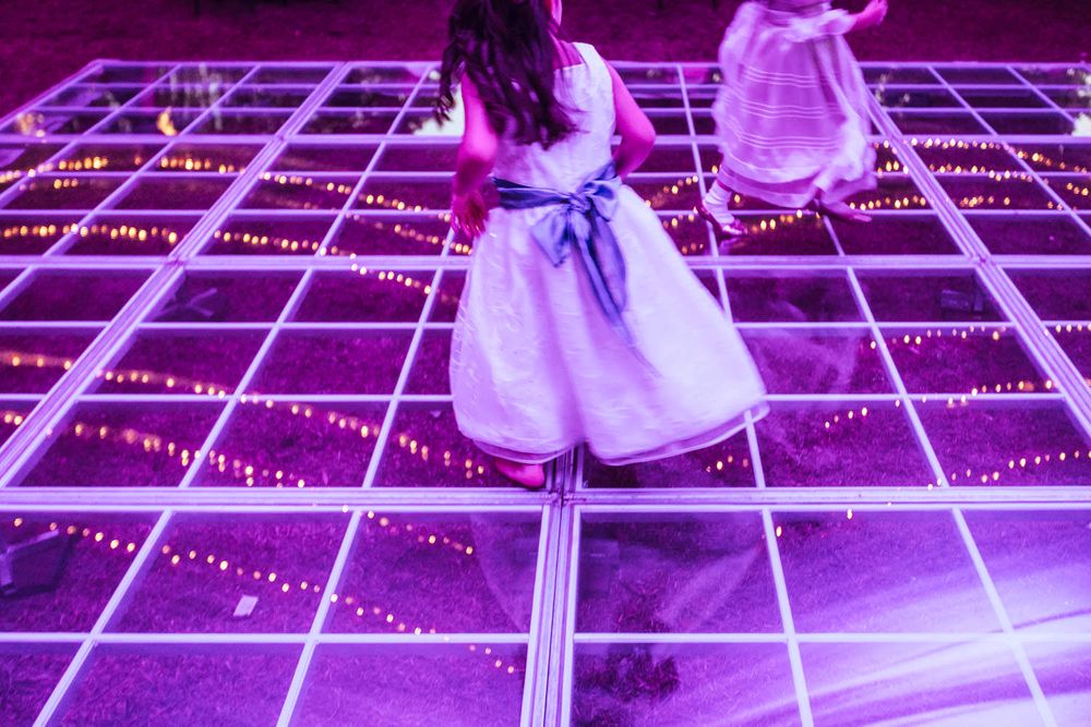 Illuminated purple dance floor with geometric grid pattern at evening reception.