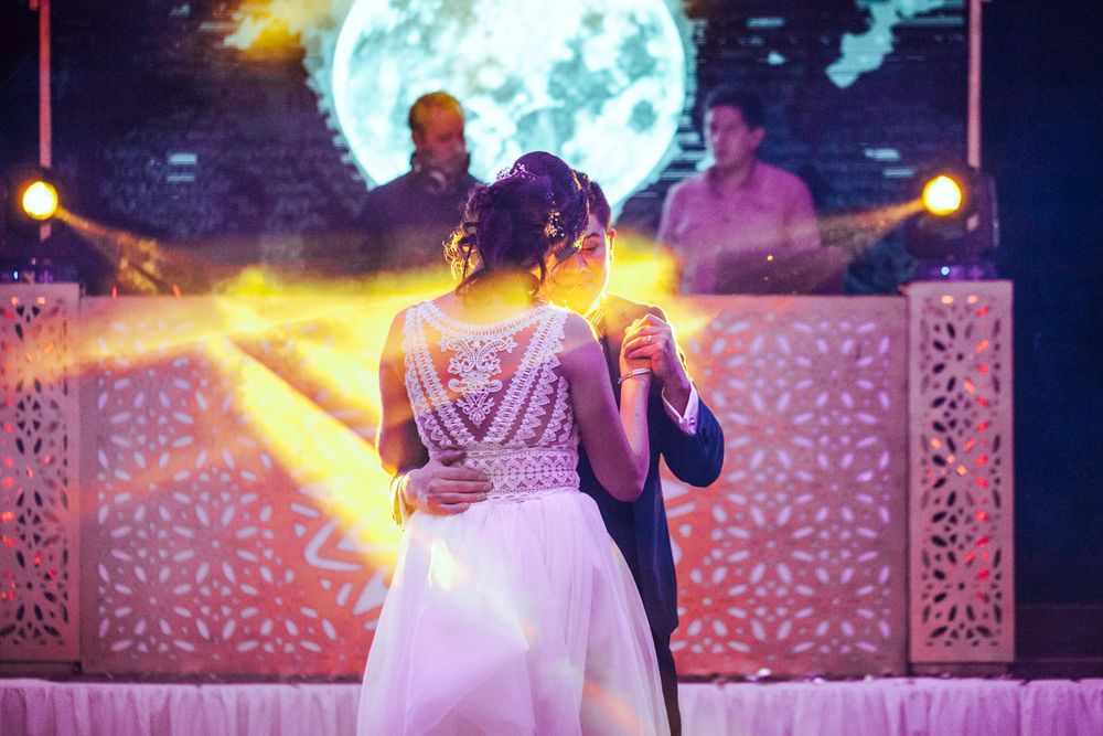 Wedding dance scene with decorative backlit panels and dramatic stage lighting.