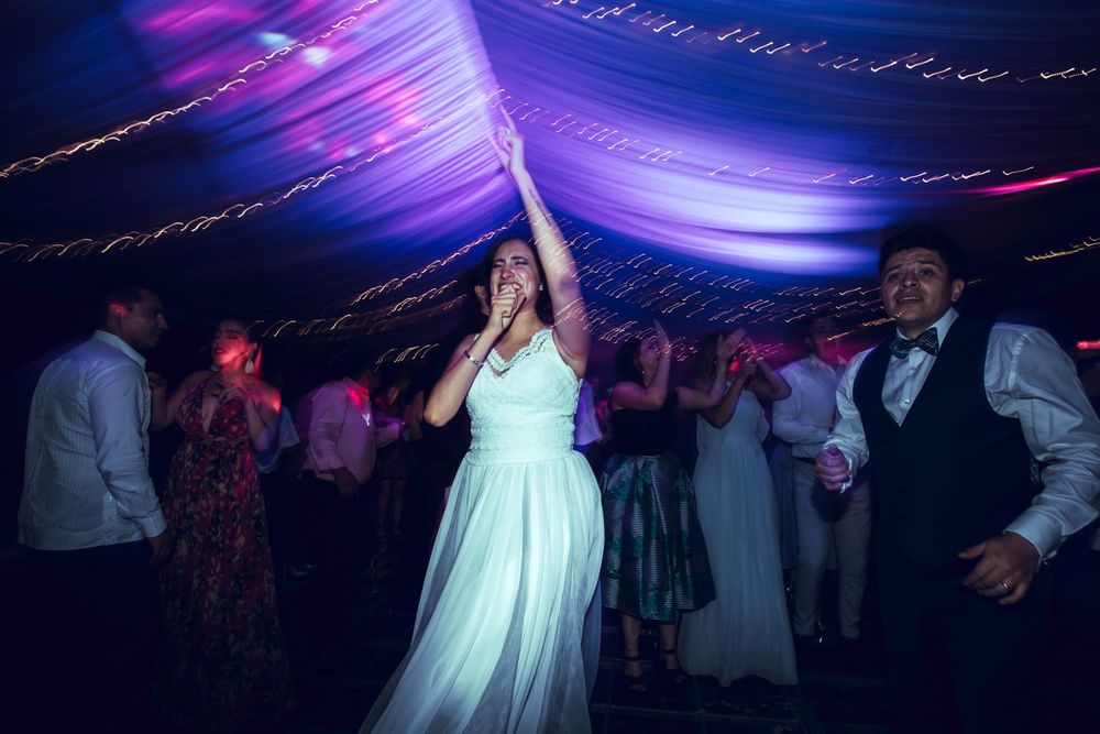 Wedding reception dance floor illuminated with purple and blue lighting effects creating a magical atmosphere.