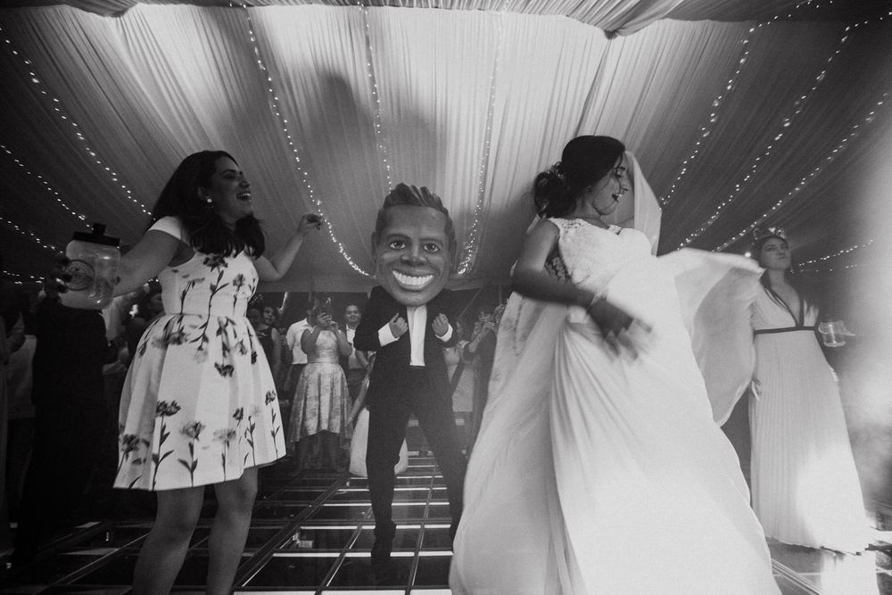 Black and white reception shots showing draped ceiling decorations and dancing guests.
