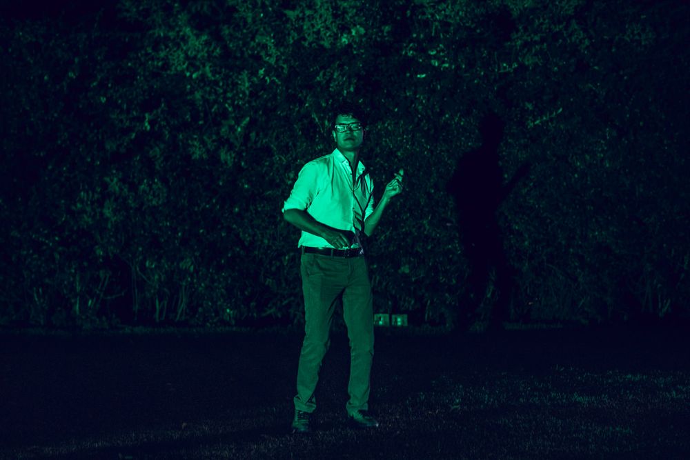 Night outdoor party scene with green lighting effects creating an ethereal atmosphere.