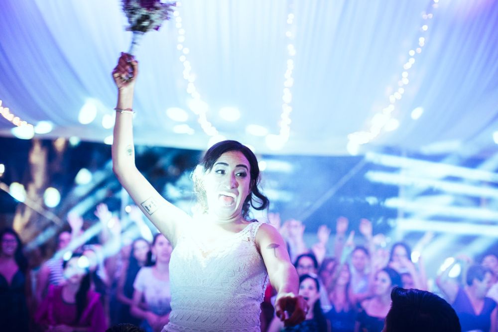 Wedding celebration under white draped ceiling with blue accent lighting and string lights.