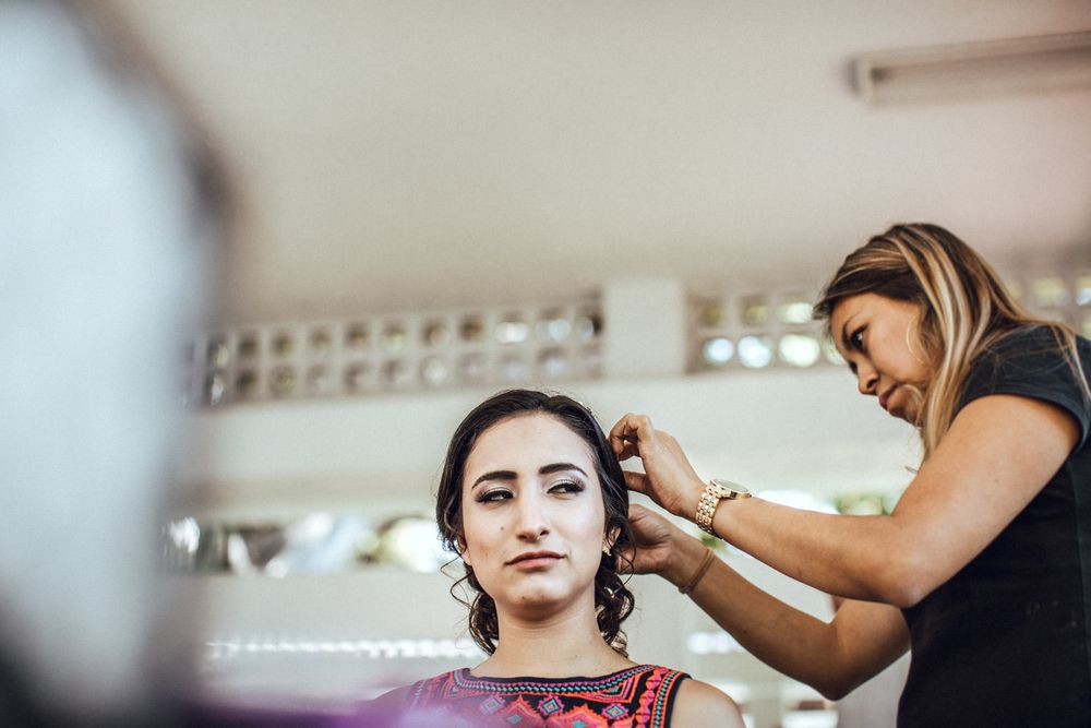 A stylist works on arranging and styling a client's hair in a salon setting.