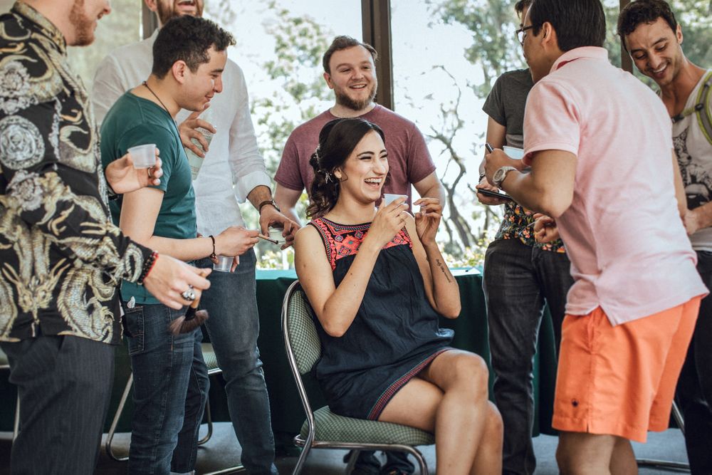 A social gathering showing people enjoying drinks and conversation outdoors.