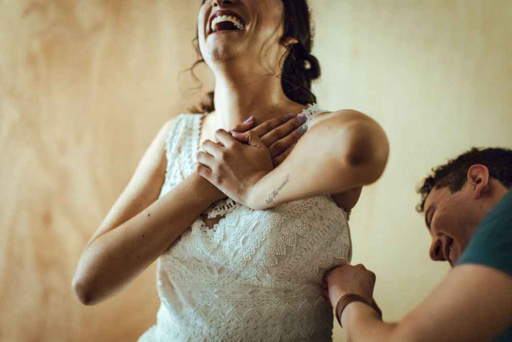 An emotional moment captured during wedding dress fitting with delicate lace details.