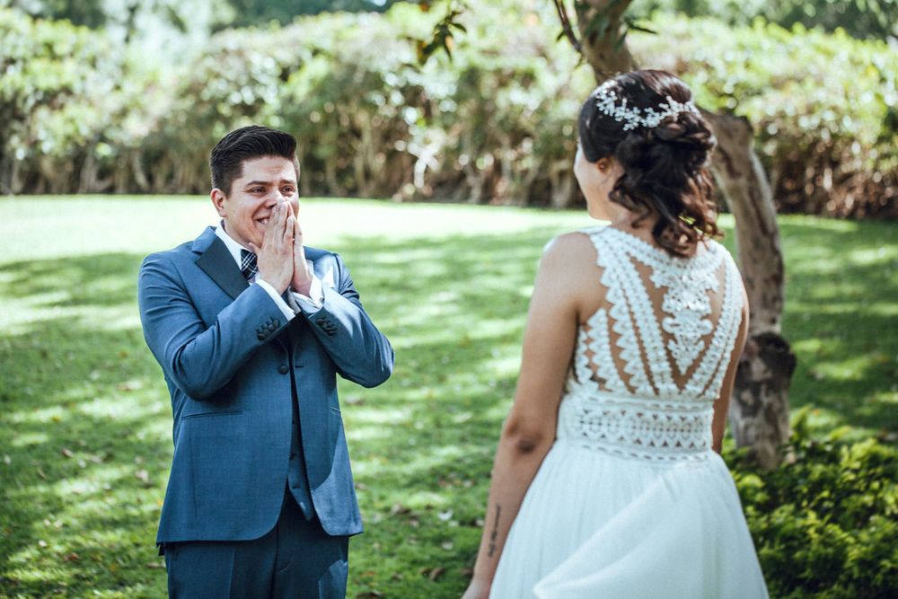 Emotional first look moment between couple in garden wedding setting.