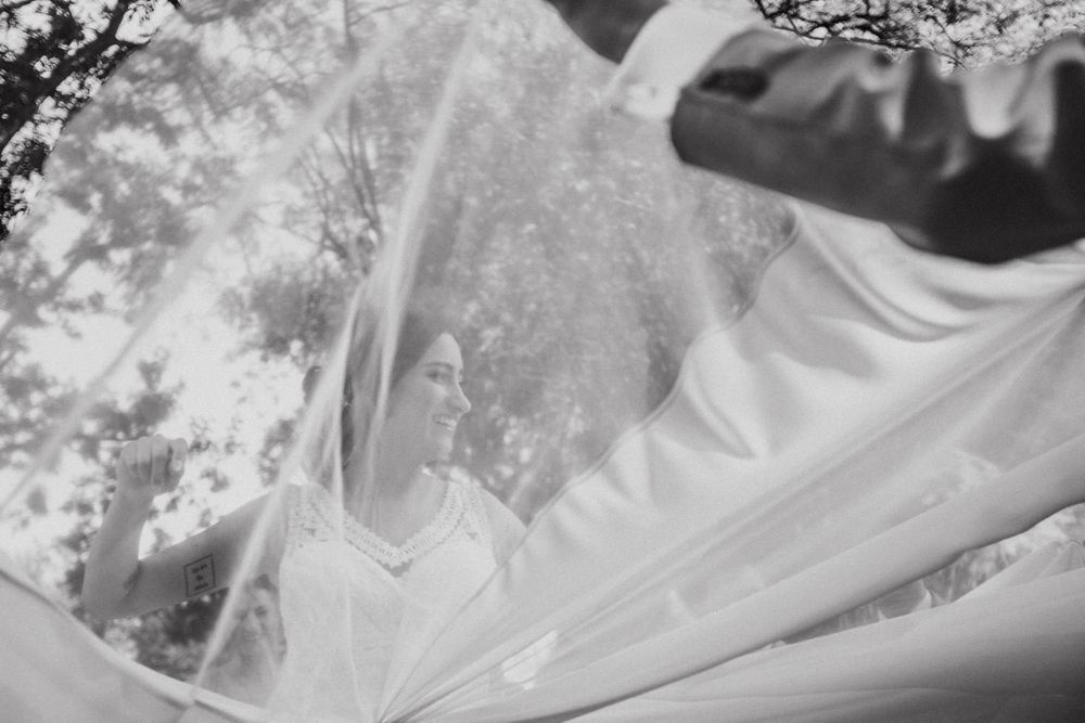 Close-up of billowing white wedding veil against grey background creating ethereal effect.