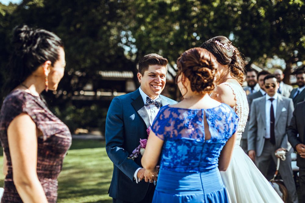 Wedding celebration outdoors with bridal party in coordinating blue and purple dresses.