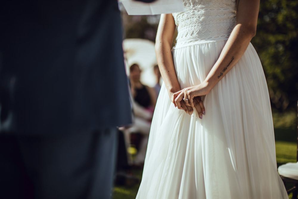 Detail shots of elegant white wedding dresses against natural outdoor backdrop.
