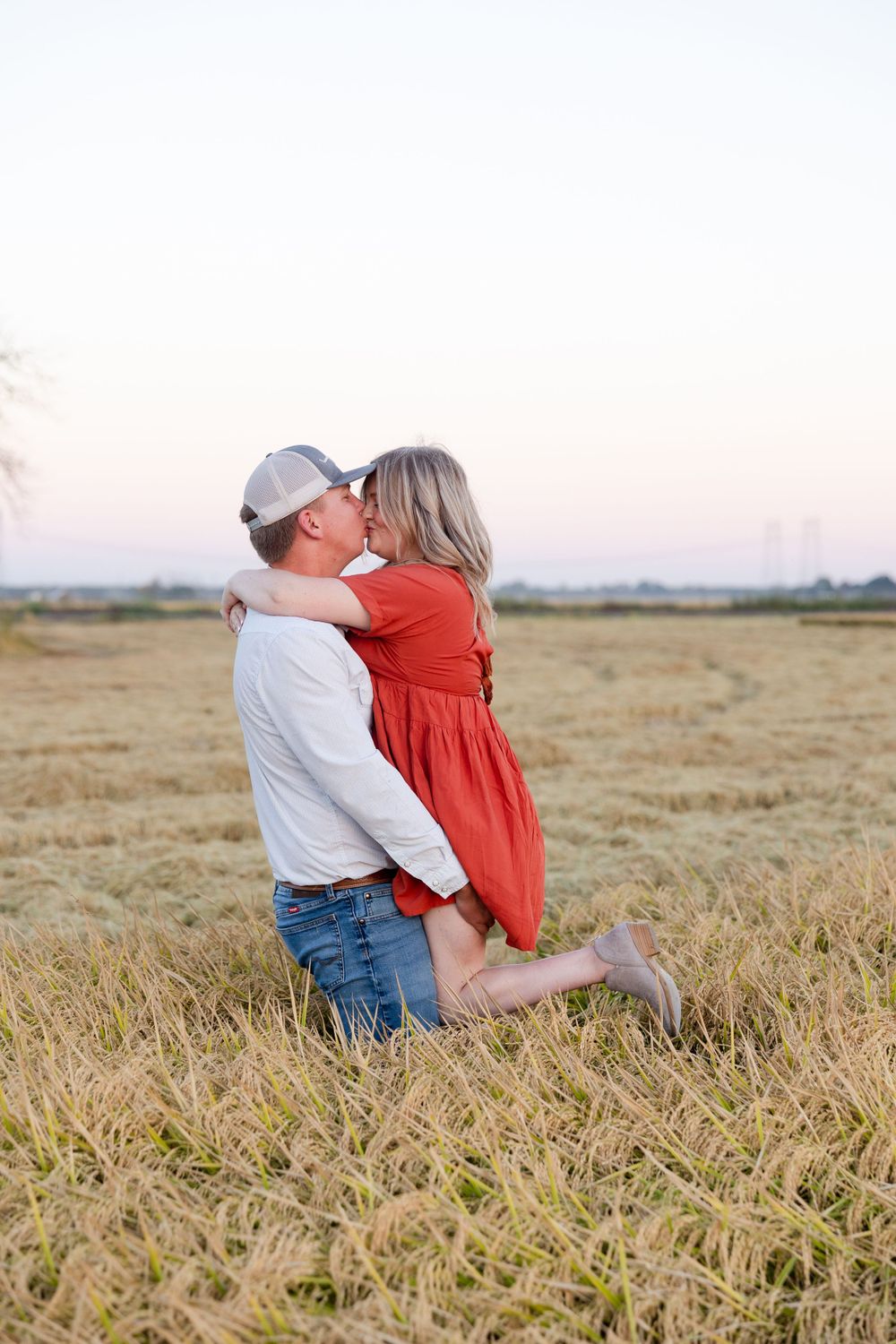 Couple kissing in a  rice field, farmer, engagement session, sunset