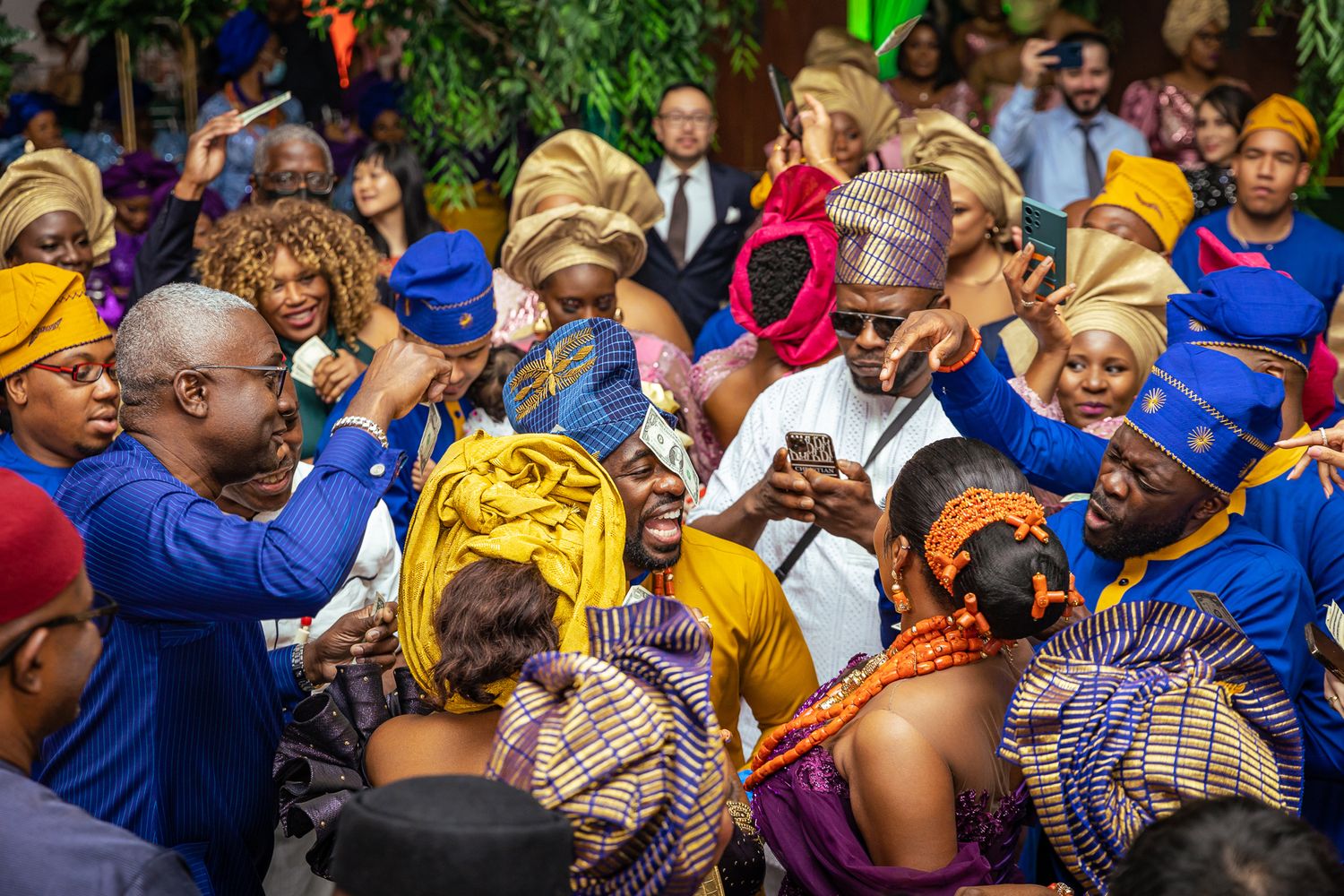 Vibrant wedding celebration with guests in traditional African attire dancing and celebrating.