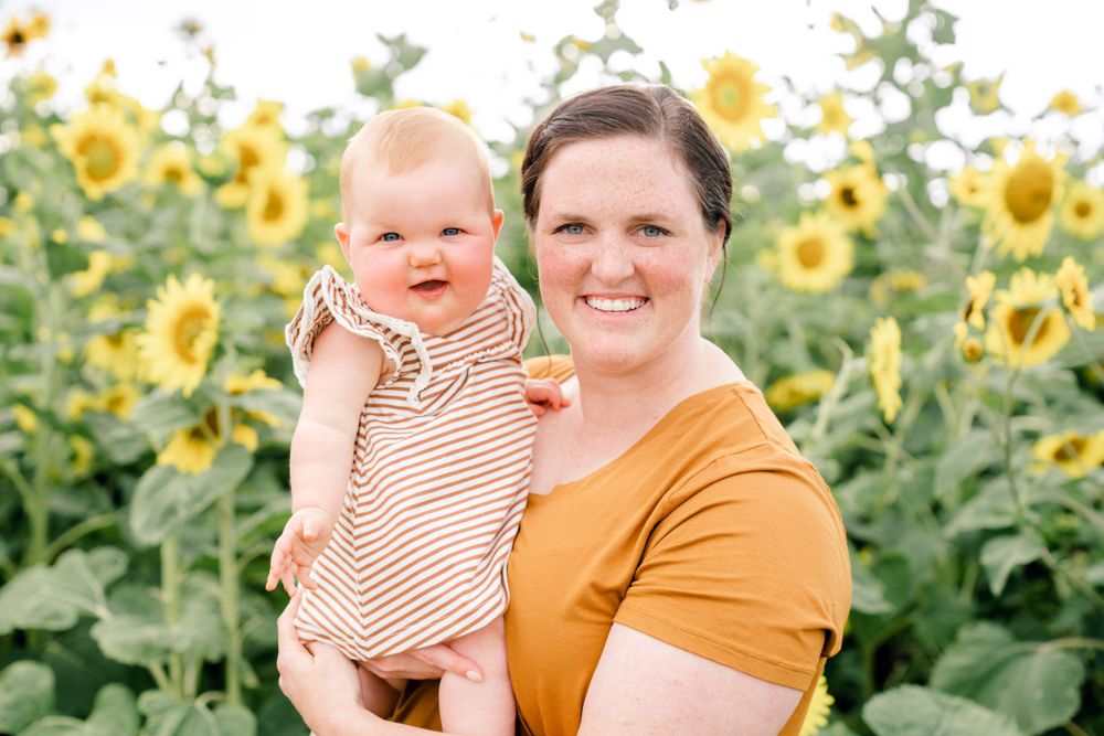 Outdoor portrait in sunflower field wearing mustard colored shirt with bright smiles.