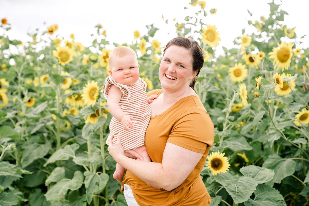 Portrait in sunflower field wearing golden yellow shirt on sunny summer day.