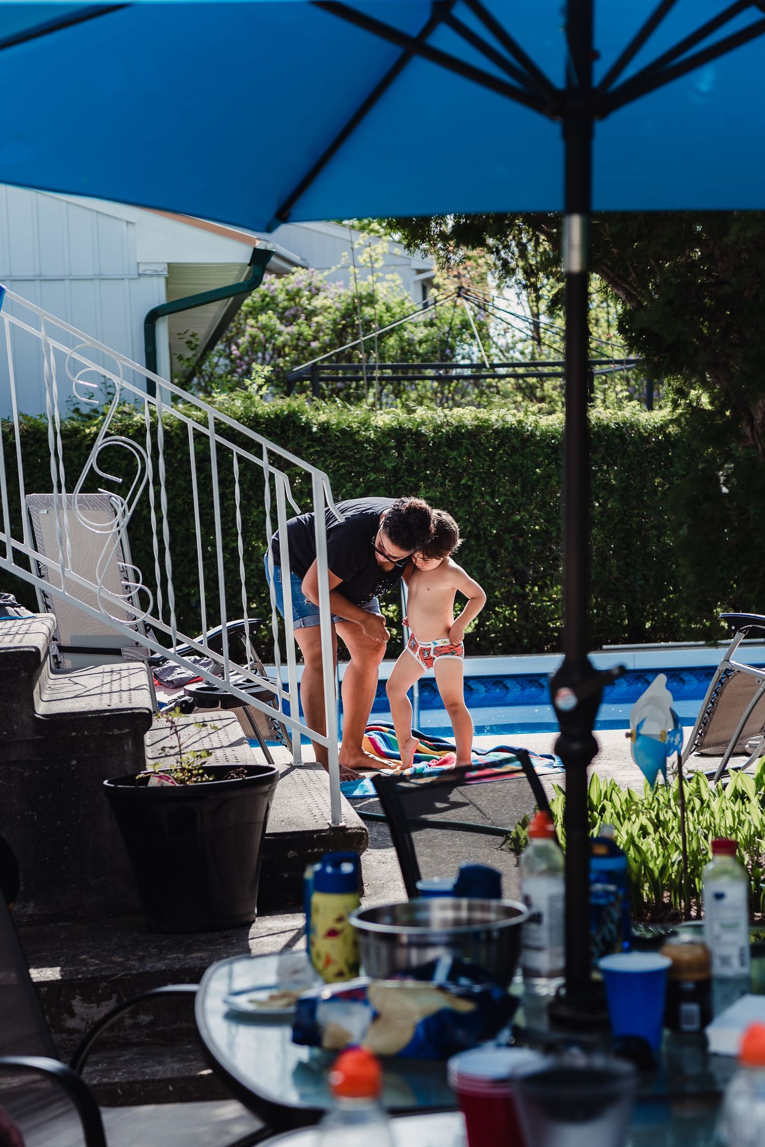 Colour image of a mom and her young son getting ready for the pool.