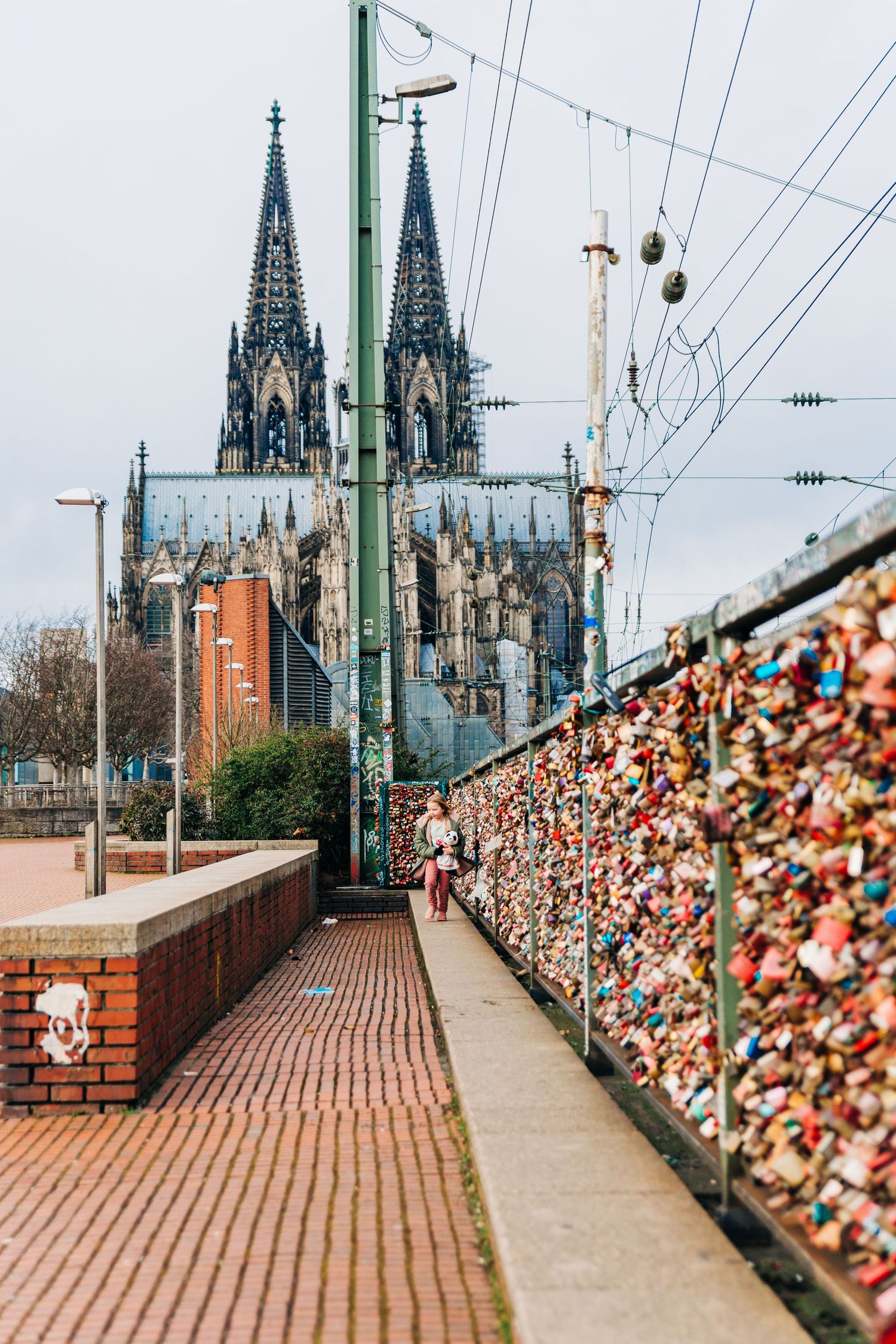 Cologne Cathedral towers behind a bridge covered in thousands of love locks.