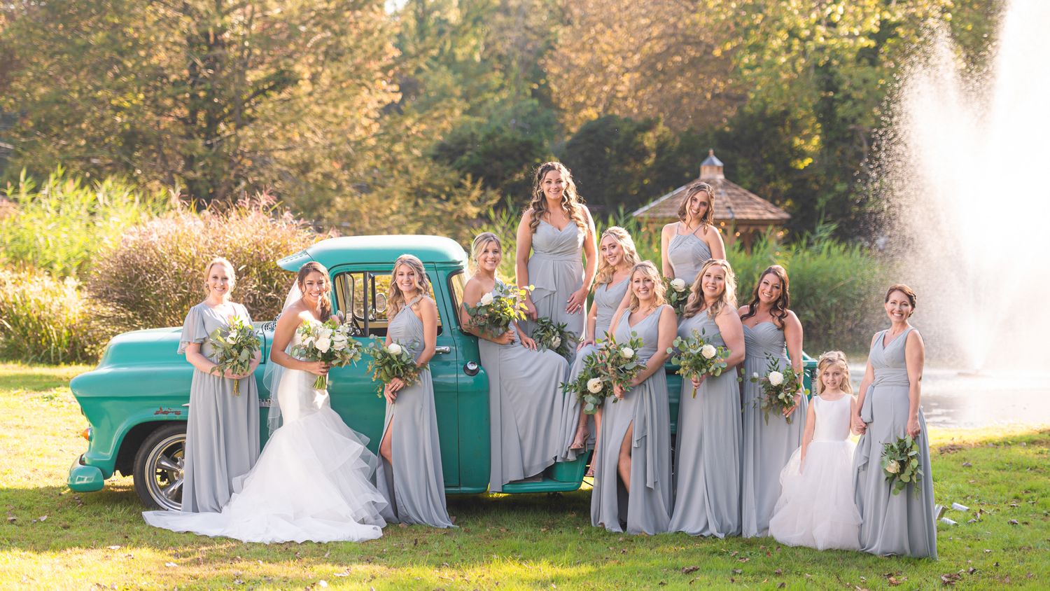 Bride and bridesmaids pose on a vintage green truck