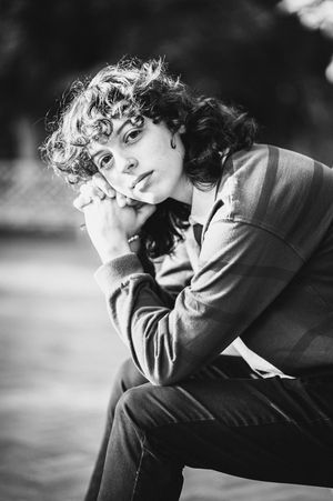 A Jackson-Reed High School senior rests her cheek on her intertwined fingers during her senior portrait session.