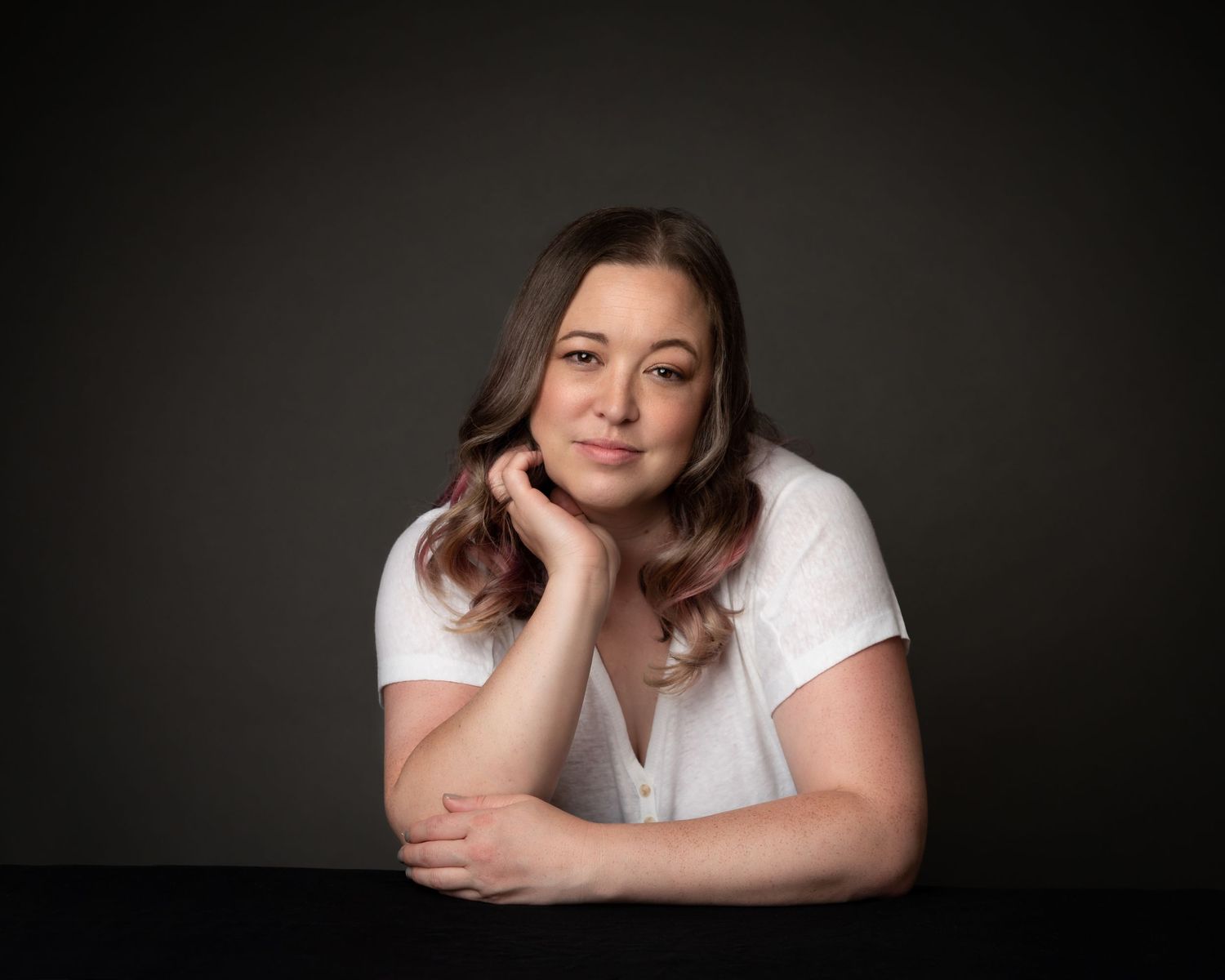 Portrait of a Billie in a white t-shirt against a dark background.