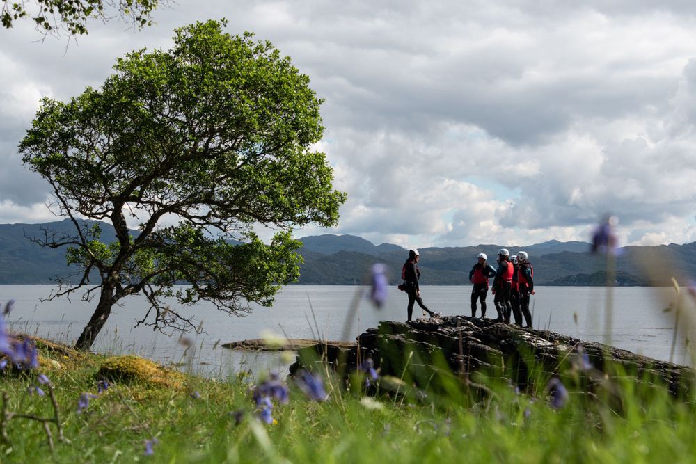 Seatrek Scotland guides briefs group under tree next to sea