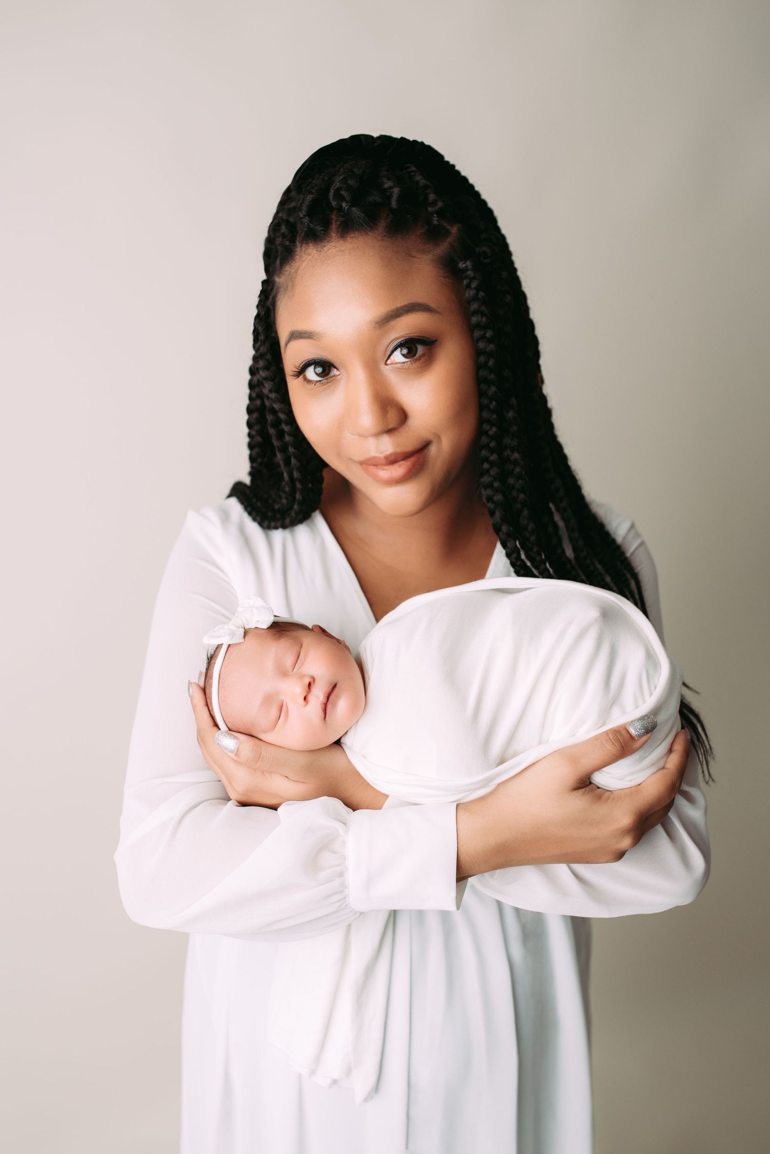 mother holding a newborn baby in her hands and looking at the camera