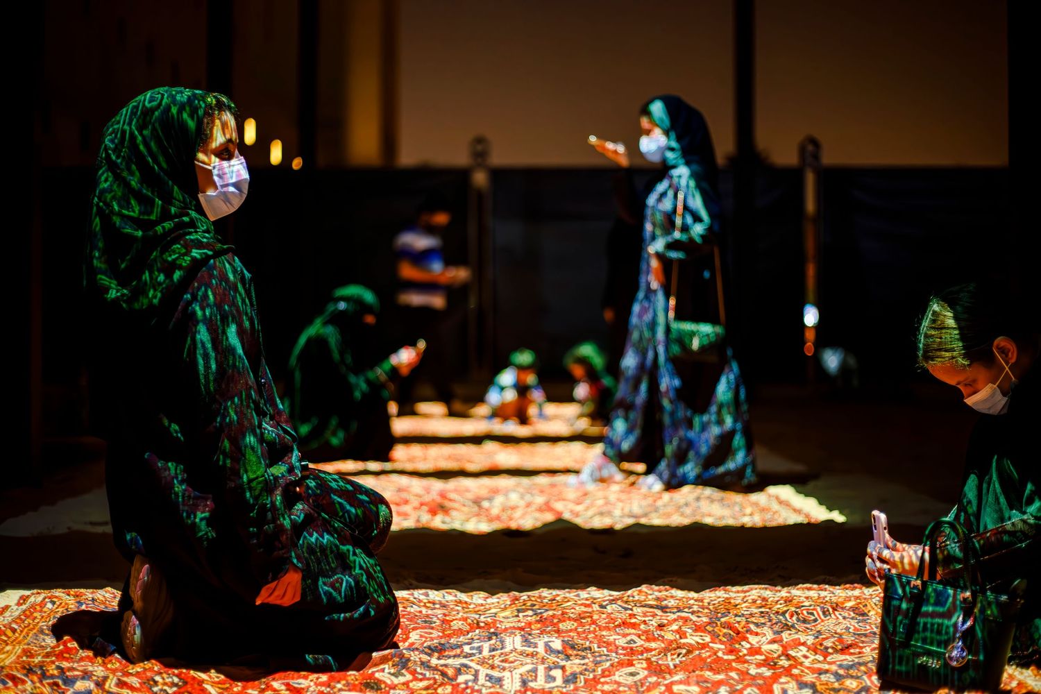 Traditional performers in elaborate costumes arranged on a decorated stage set.