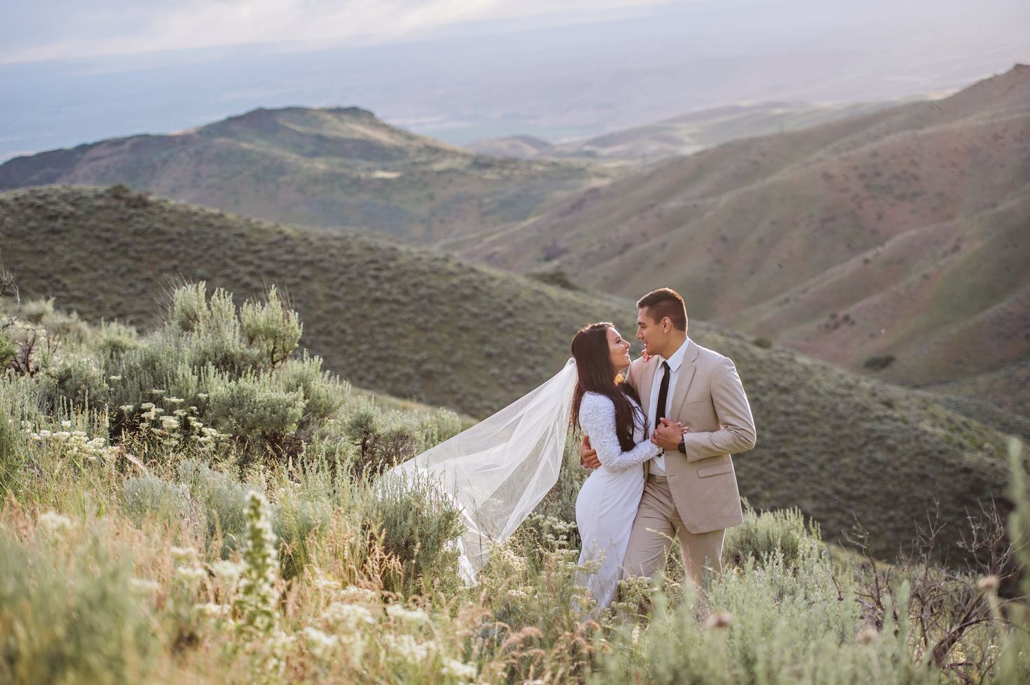 A young bride and groom gaze at each other in a beautiful desert setting near Boise, Idaho