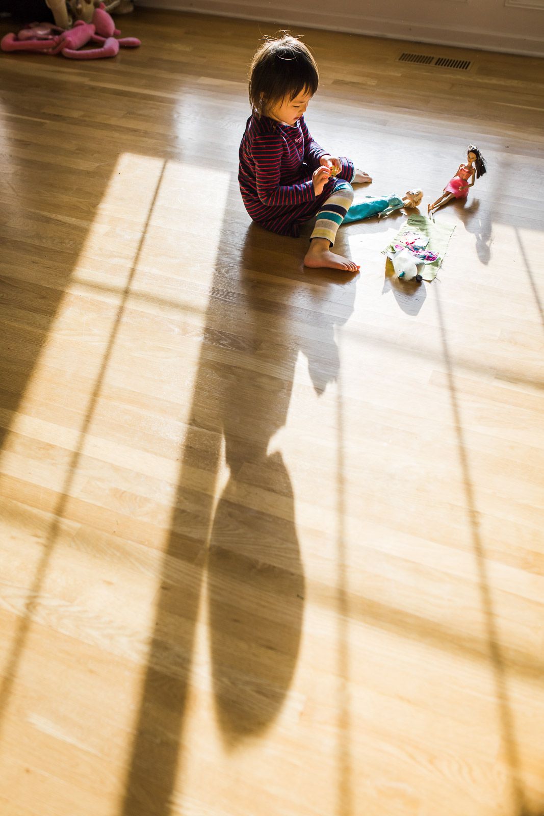 Little girl playing with her toys with shadows and leading lines