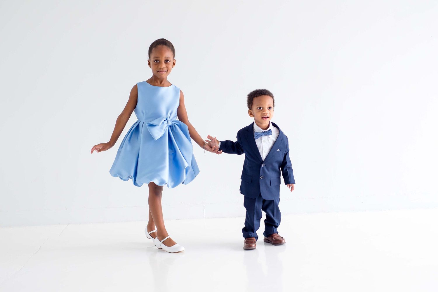 brother and sister taking portraits in a white studio in houston texas