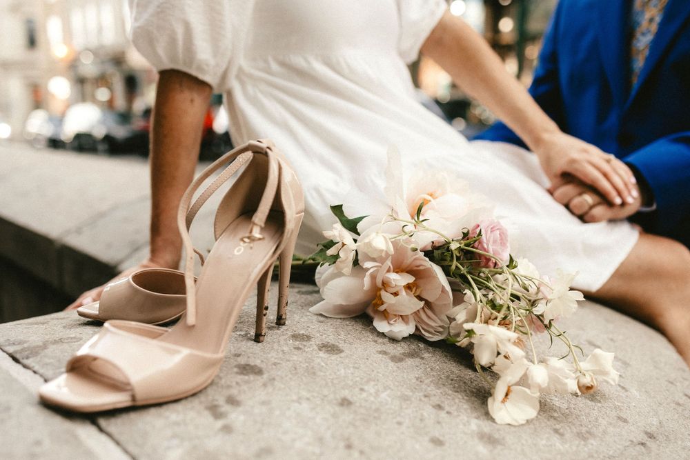 Elegant nude heels and delicate floral bouquet arranged on stone steps.