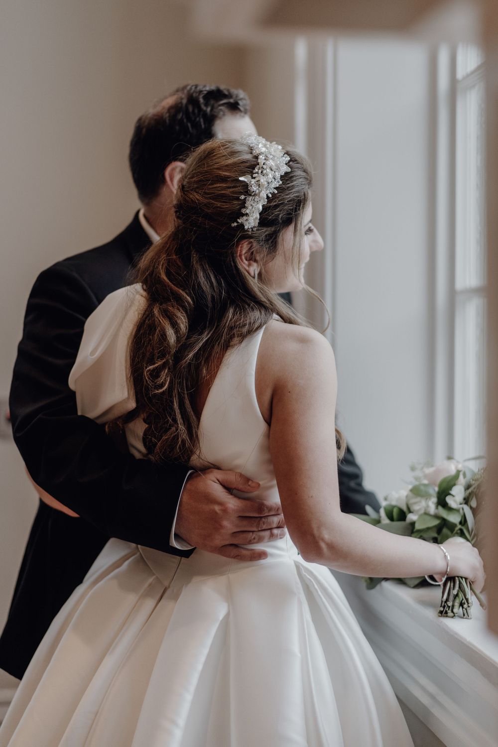 Bride and Groom hugging, looking out a window