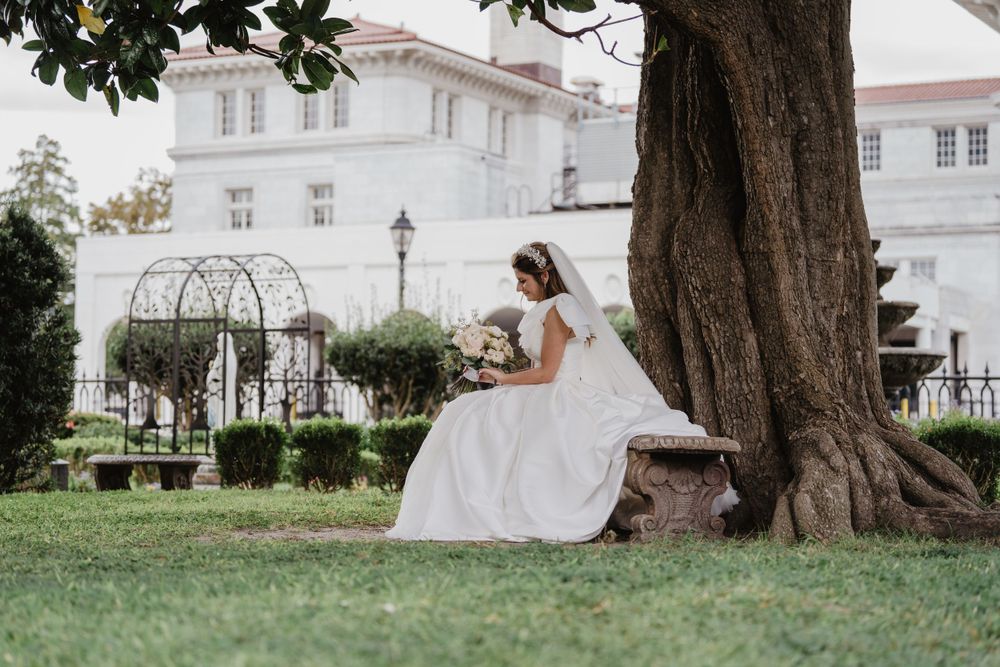 Bride sitting under a tree near the church