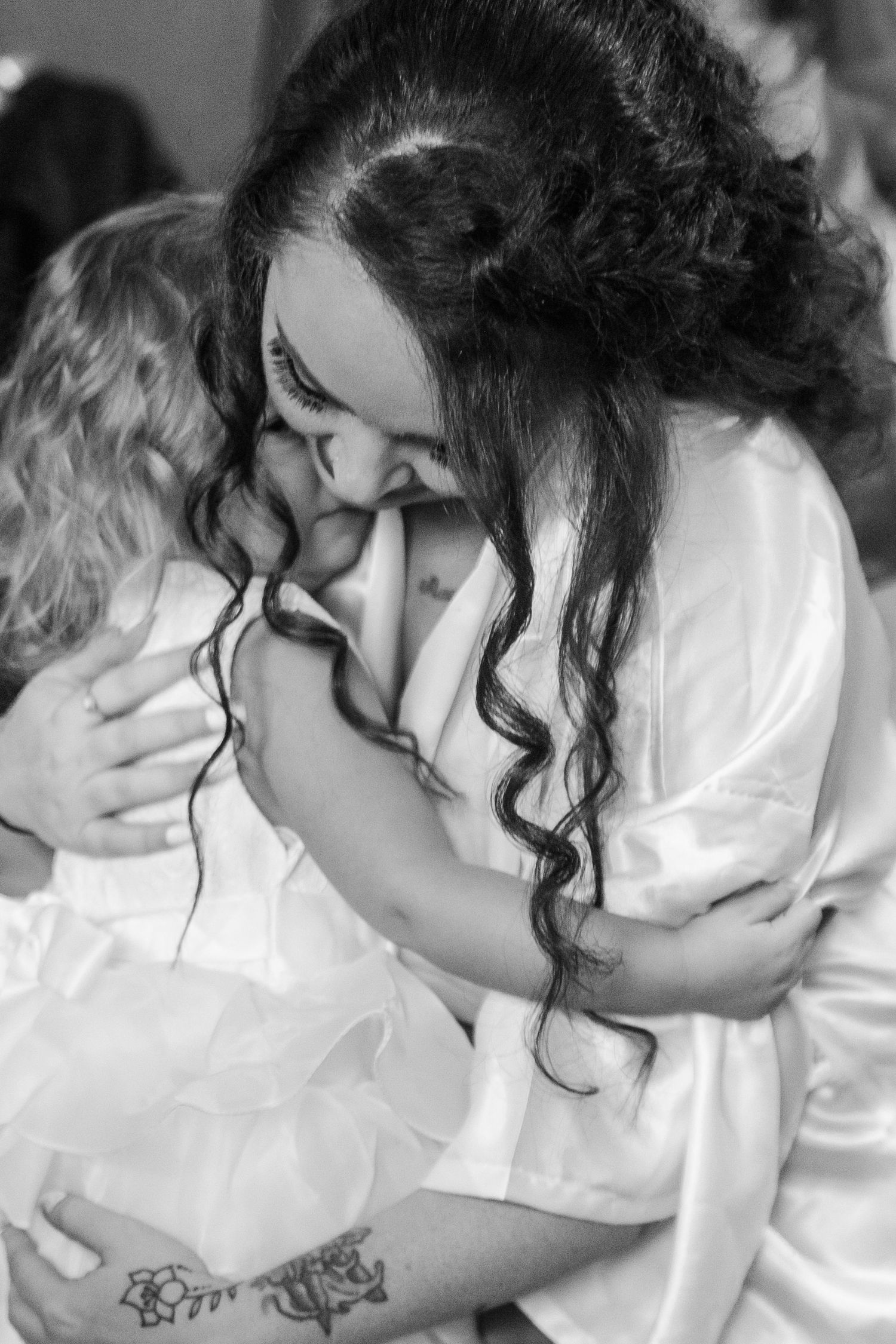 Intimate black and white portrait of couple sharing tender moment in bridal attire.