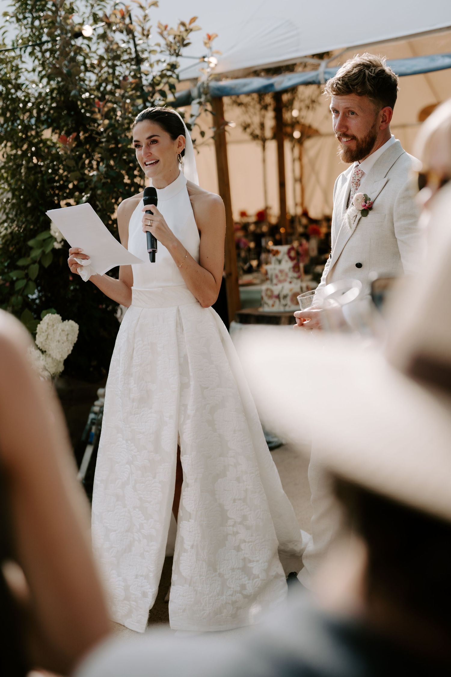 bride giving speech stood next to groom at marquee wedding in islip in Oxfordshire